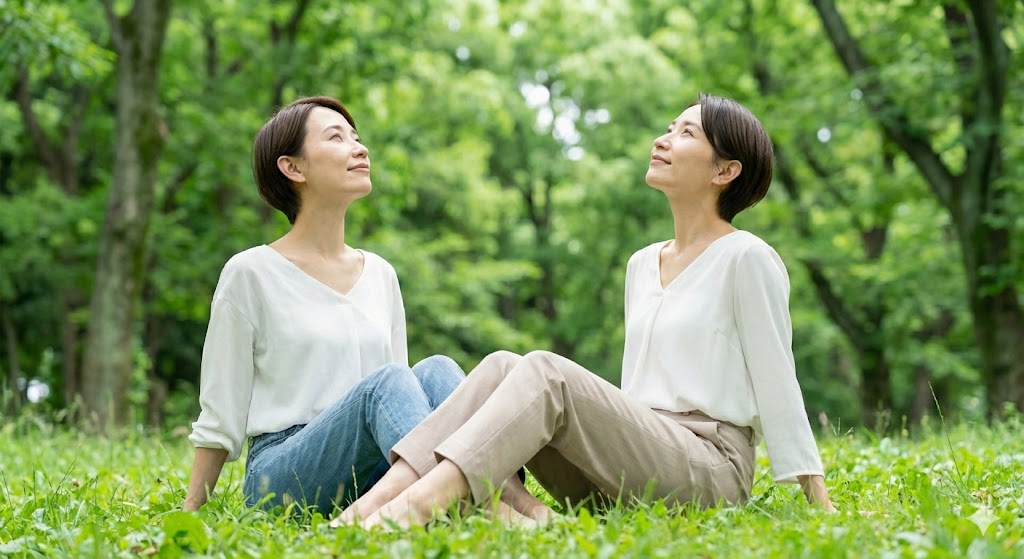 緑豊かな自然の中でスマホを手放し空を見上げて深呼吸する女性。デジタルデトックスでリラックスし守護霊からのサインに気づく感度を磨くイメージ。